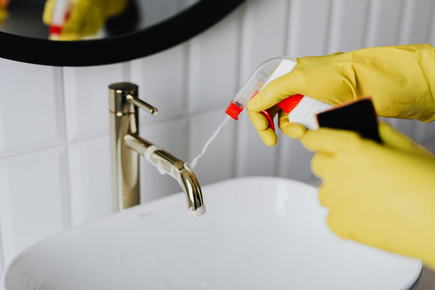 A person cleaning a tap