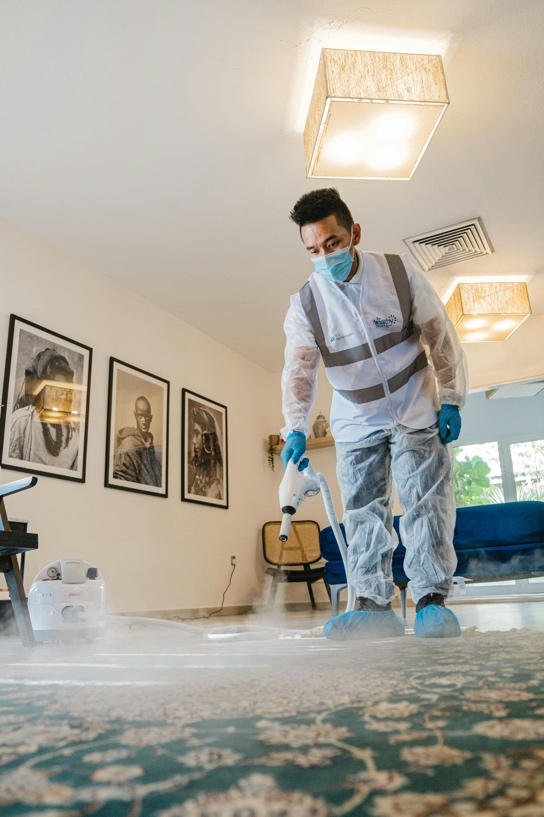 A man cleaning a carpet with disinfectant