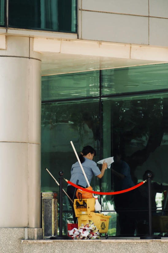 Woman cleaning a window in a school facility